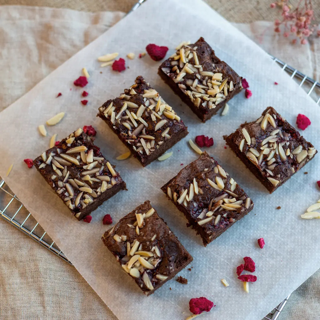 6 Stück Himbeer-Mandel Brownies auf einem Gitter von oben