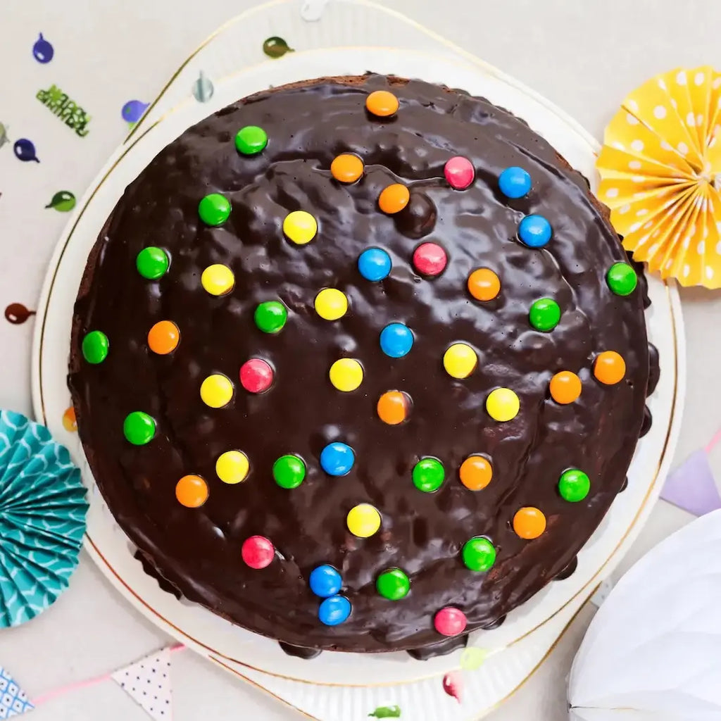 großer, bunter Schokokuchen für Kinder von Oma Anna von Kuchentratsch, dekoriert mit Schokolinsen auf einer Kuchenplatte