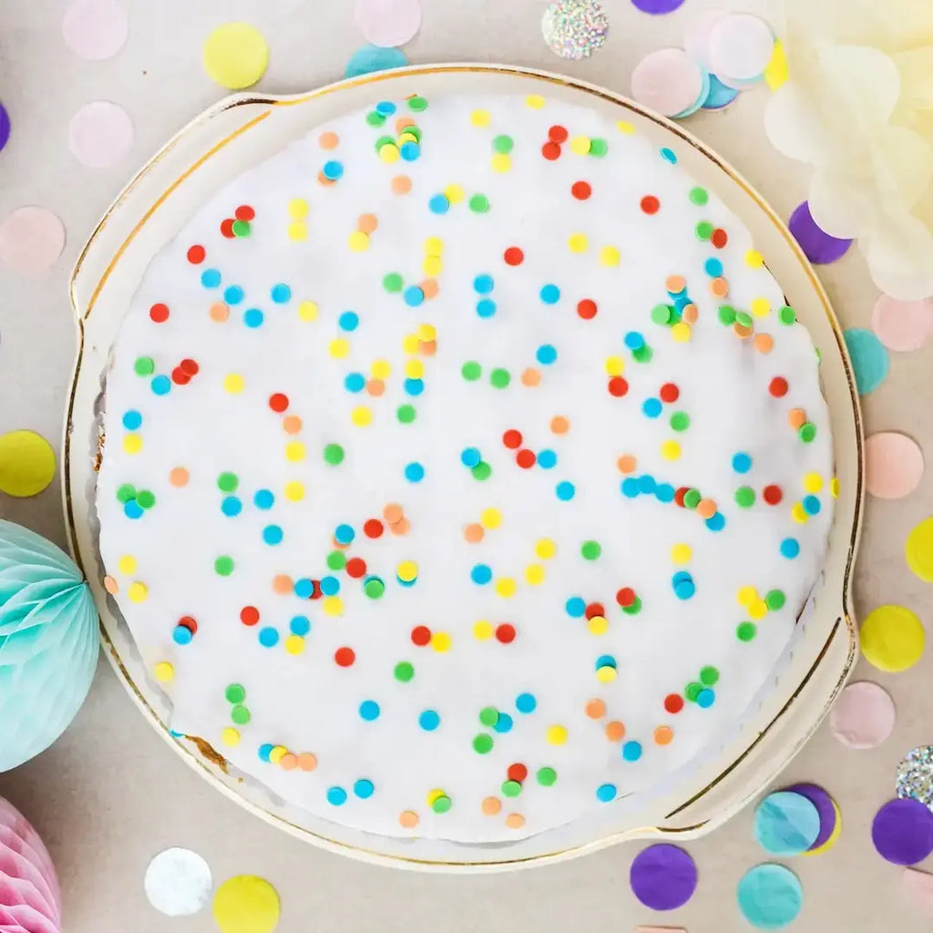 großer Konfetti-Karottenkuchen für Kinder von Oma Irmgard von Kuchentratsch auf Kuchenplatte, dekoriert mit Zuckerguss und bunten Konfetti-Streuseln