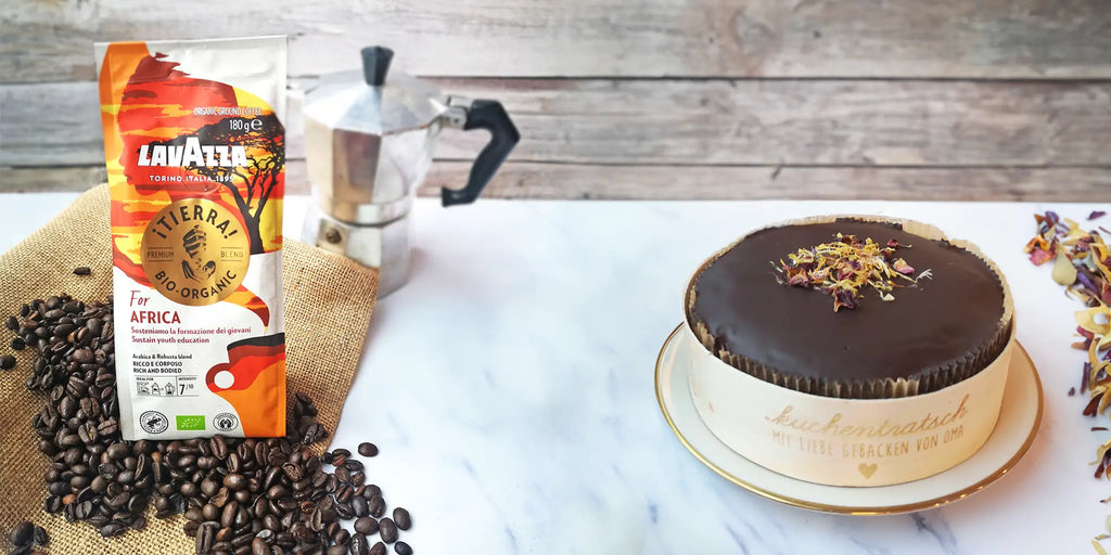 Kaffemischung „iTierra for Africa" von Lavazza und Mini Schokoladenkuchen von Oma Anna auf dekoriertem Tisch mit Espresso-Kanne